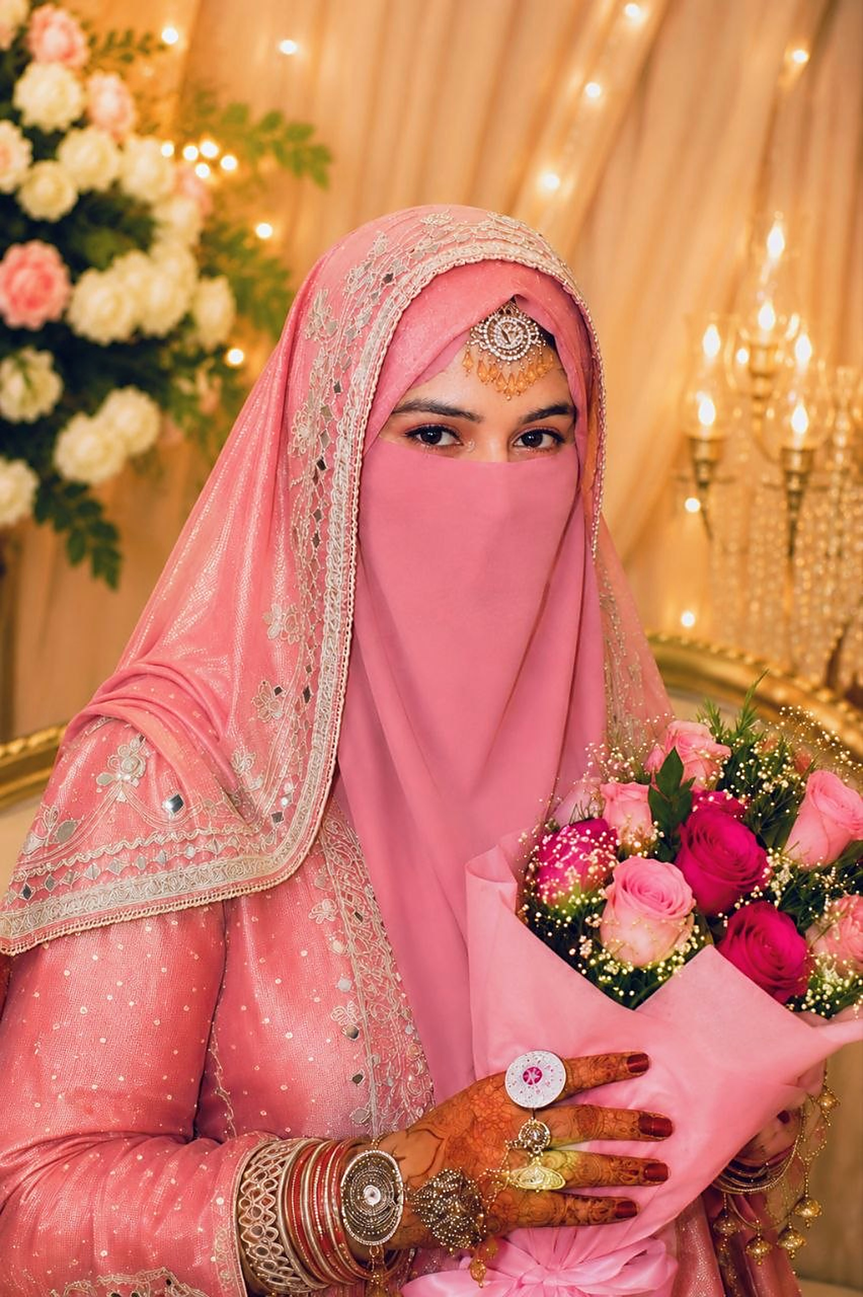 Bride holding a bouquet of pink roses